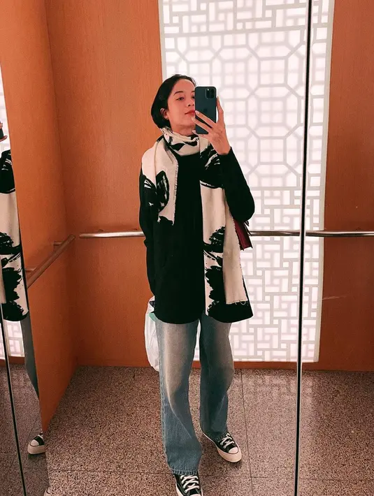 Dengan syal yang sama, Putri Marino padukan long sleeve hitam dan straight jeans [@putrimarino]