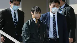 Kabu Terauchi (kedua kiri) meninggalkan rumah sakit dengan pengawalan polisi di Izunokuni, Jepang, Kamis (31/3). Pria 23 tahun asal Nakano itu menculik dan menyekap gadis remaja (15) selama dua tahun di dalam apartemen miliknya. (JIJI PRESS/AFP)