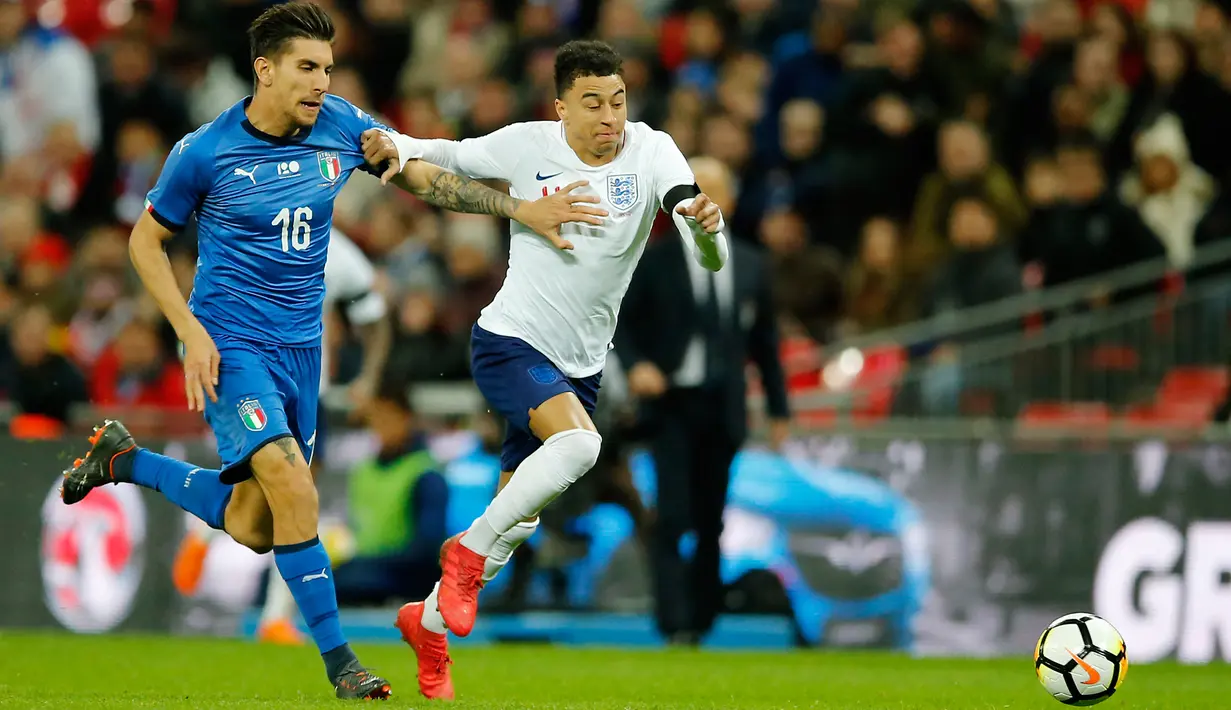 Pemain timnas Italia, Lorenzo Pellegrini berebut bola dengan pemain timnas Inggris, Jesse Lingard dalam laga persahabatan di Stadion Wembley, London, Rabu (28/3).  Inggris gagal meraih kemenangan setelah ditahan Italia 1-1. (AP Photo/Alastair Grant)