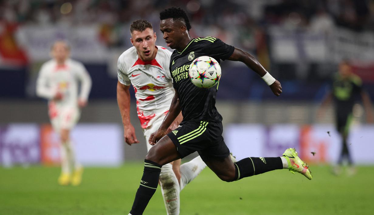 Striker Real Madrid, Vinicius Junior menguasai bola dibayangi bek RB Leipzig, Willi Orban pada fase Grup F Liga Champions 2022/2023 di Leipzig, Jerman (25/10/2022). Satu gol juga dicetak Vinicius Junior ke gawang RB Leipzig di matchday kelima fase grup Liga Champions musim 2022/2023 (25/10/2022). (AFP/Ronny Hartmann)