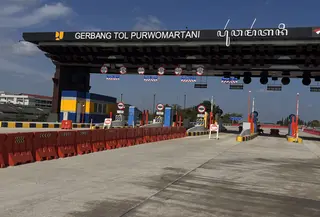 Deretan gardu biru berdiri rapi di bawah bentang atap baja hitam di Gerbang Tol Purwomartani, menjadi bagian dari perjalanan Tol Prambanan-Purwomartani. (Liputan6.com/Ady Anugrahadi)