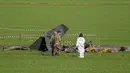 Polisi forensik (kanan) dan prajurit angkatan udara memeriksa sisa-sisa yang terbakar  salah satu dari dua pesawat U-208 Angkatan Udara Italia yang jatuh di Guidonia, di pinggiran Roma, Selasa (7/3/2023). Saat ini penyebab tabrakan tidak diketahui dan dewan penyelidikan sedang dibentuk.  (AP Photo/Andrew Medichini)