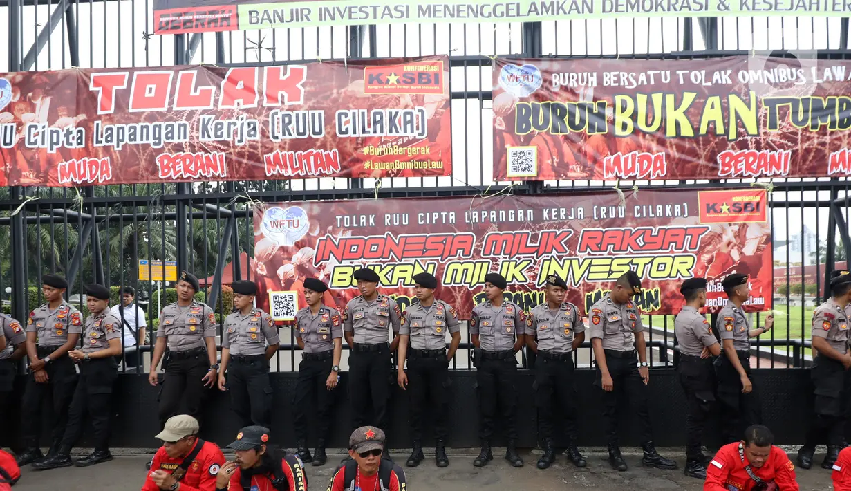 Polisi berjaga saat buruh yang tergabung dalam Gerakan Buruh Bersama Rakyat (Gebrak) berdemonstrasi di depan Gedung DPR, Jakarta, Senin (13/1/2020). Massa menyuarakan penolakan mereka terhadap Omnibus Law Rancangan Undang-Undang Cipta Lapangan Kerja. (Liputan6.con/Johan Tallo)