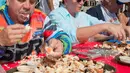 Para peserta beradu cepat memakan daging kepiting batu dalam kontes Key Fisheries Stone Crab Eating di Marathon, Florida, Sabtu (10/11). Mereka harus memecahkan cangkang 25 kepiting batu lalu memakan dagingnya. (Andy Newman/Florida Keys News Bureau/AFP)