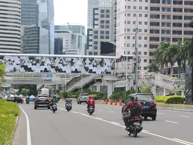 Kendaraan melintas di Jalan Jenderal Sudirman, Jakarta, Jumat (4/1). Revitalisasi jembatan penyeberangan orang (JPO) Dukuh Atas sudah rampung. (Liputan6.com/Herman Zakharia)