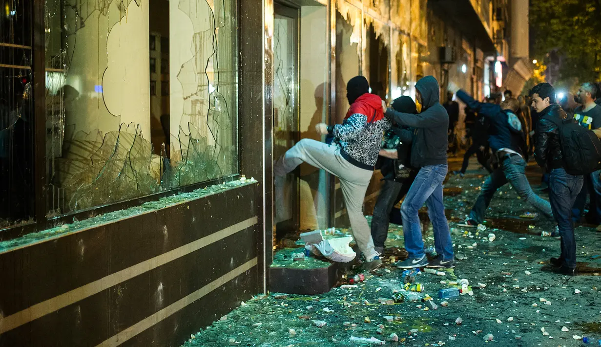Pengunjuk rasa merusak kantor Presiden Gjorge Ivanov di jalanan ibu kota Makedonia, Skopje, Rabu (13/4). Sebelumnya, ribuan demonstran melakukan unjuk rasa memprotes keputusan Presiden memberikan pengampunan bagi 56 politikus. (Robert ATANASOVSKI/AFP)