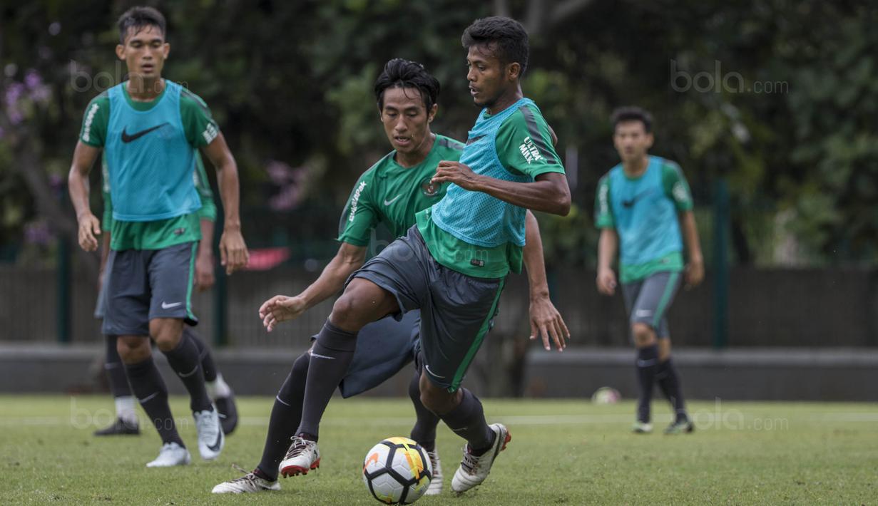 Pemain Timnas Indonesia, Zulfiandi, berusaha melewati Hanif Sjahbandi saat latihan di Lapangan ABC Senayan, Jakarta, Jumat (19/1/2018). Pemusatan latihan ini dilakukan jelang Asian Games 2018. (Bola.com/Vitalis Yogi Trisna)
