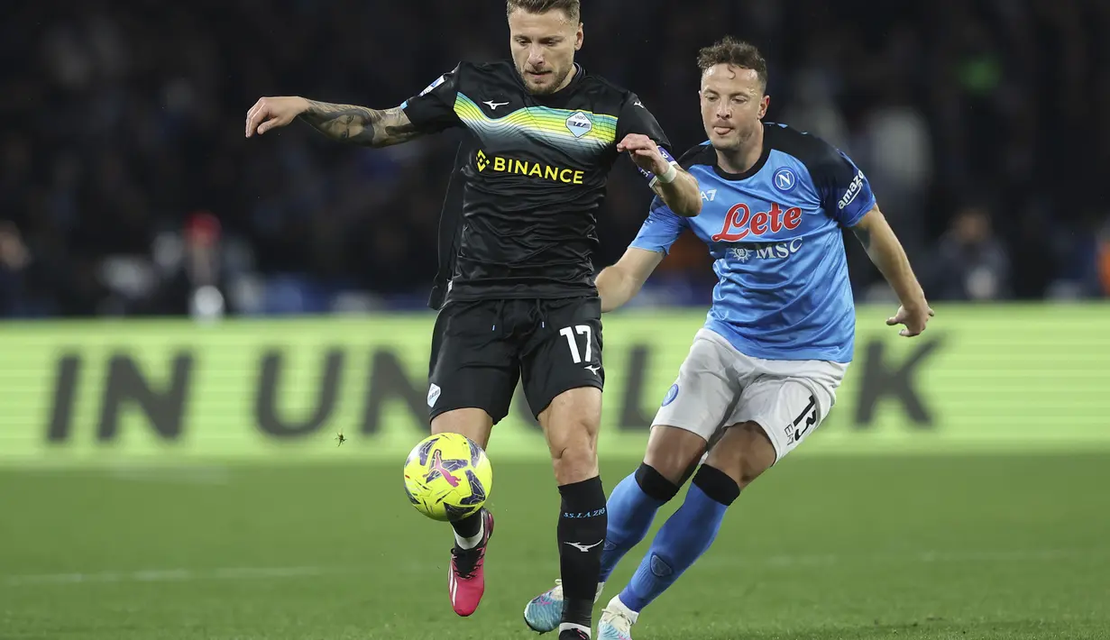 Penyerang Lazio Ciro Immobile berebut bola dengan bek Napoli Amir Rrahmani pada giornata ke-25 Liga Italia di Stadion Diego Armando Maradona, Sabtu (4/3/2023) dini hari WIB. Meski kalah, posisi Napoli masih aman di puncak klasemen Liga Italia dengan 65 poin dari 25 pertandingan. (Alessandro Garofalo/LaPresse via AP)