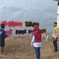 Polisi bersama aparat kelurahan dan warga menghapus tulisan vandalisme bernada rasis di sejumlah titik di Kelurahan Nunu Kota Palu, Jumat pagi (16/2/2024). (Foto: Heri Susanto/ Liputan6.com)