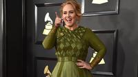 Penyanyi asal Inggris, Adele bereaksi saat berpose di karpet merah ajang bergengsi Grammy Awards 2017, di Staples Center, Los Angeles, Minggu (12/2). Pelantun "Hello" itu tampil dengan gaya busananya yang khas. (Photo by Jordan Strauss/Invision/AP)