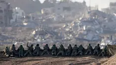 Sebuah foto yang diambil di Israel selatan dekat perbatasan dengan Jalur Gaza pada 11 Desember 2023, menunjukkan tentara Israel berjaga di sebuah bukit yang menghadap ke Gaza utara, di tengah pertempuran yang terus berlanjut antara Israel dan kelompok militan Hamas. (Menahem KAHANA/AFP)