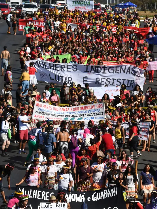 Perempuan pribumi berjalan kaki saat menggelar protes terkait kebijakan Presiden Brasil Jair Bolsonaro di Brasilia, Selasa (13/8/2019). Perempuan pribumi Brasil berdemonstrasi mengecam rencana Bolsonaro membuka hutan hujan Amazon untuk penambangan dan agribisnis. (EVARISTO SA/AFP)