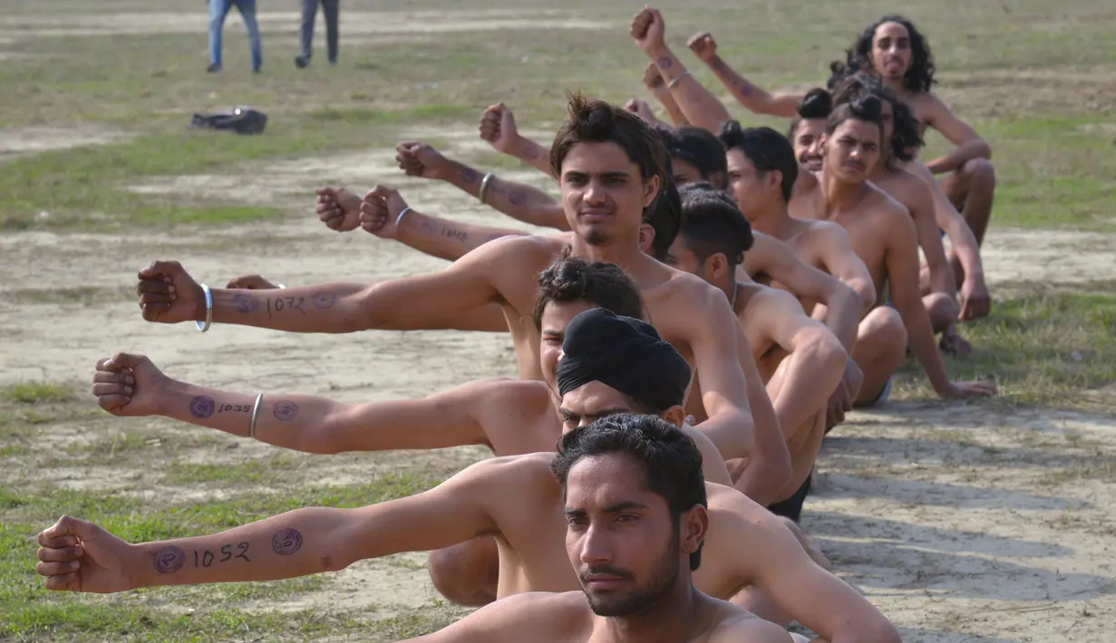 Calon tentara India menunjukkan nomor peserta pada perekrutan tentara India di Khasa, Amritsar, (6/2). Orang-orang Sikh terkenal pemberani, dan sejak lama banyak yang bergabung ke dalam dinas ketentaraan Inggris. (AFP Photo / Narinder Nanu)