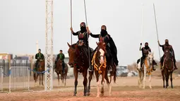 Perempuan Arab menunggangi kuda selama Festival Souk Okaz 2019 di Kota Taif, Arab Saudi, Rabu (7/8/2019). Perempuan penunggang kuda dari berbagai negara Arab ambil bagian dalam Festival Souq Okaz 2019. (AMER HILABI/AFP)