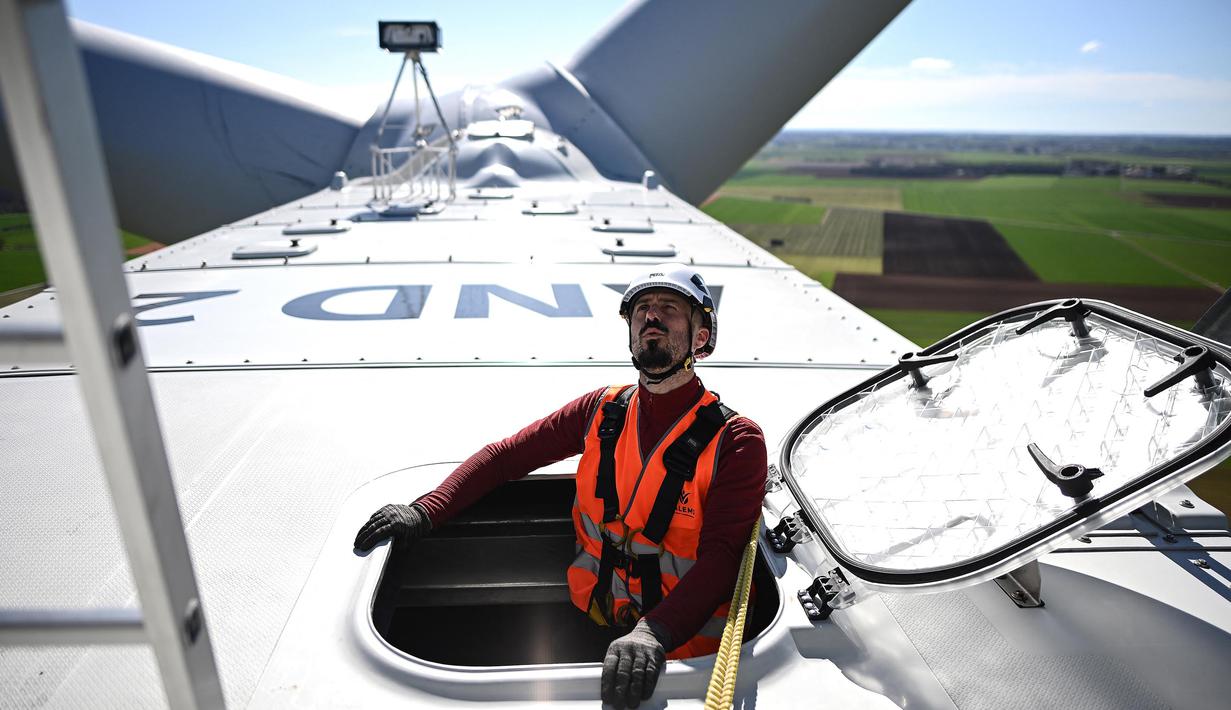 Seorang operator teknis mengamati dari sebuah palka di atap ruang mesin yang terletak di bagian atas turbin angin saat kegiatan pemeliharaan di Andilly-les-Marais dekat La Rochelle, Prancis barat pada tanggal 10 Maret 2025. (Christophe ARCHAMBAULT/AFP)