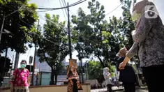 Sejumlah pegawai berjemur di bawah sinar matahari di Kawasan Fatmawati, Jakarta, Selasa (31/3/2020). Berjemur diri di bawah sinar matahari saat pagi merupakan salah satu upaya yang paling sederhana untuk menjaga kesehatan selama wabah virus COVID-19. (Liputan6.com/Faizal Fanani)