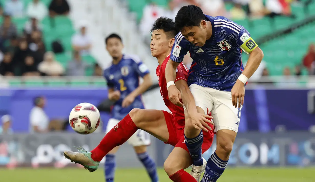 Pemain Vietnam, Nguyen Dinh Bac (kiri) berebut bola dengan pemain Jepang, Wataru Endo pada laga Grup D Piala Asia 2023 di Al Thumama Stadium, Qatar, Minggu (14/01/2024). (AFP/Karim Jaafar)