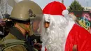 Pengunjuk rasa berkostum sinterklas (Santa Claus) berargumen dengan polisi perbatasan Israel dalam demonstrasi di Bethlehem, Tepi Barat, 23 Desember 2017. Protes terkait pengakuan Donald Trump atas Yerusalem sebagai Ibu Kota Israel. (AP/Nasser Shiyoukhi)