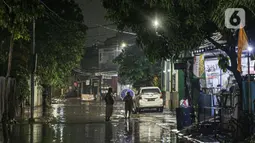 Warga melintas di genangan banjir di kawasan Mampang Prapatan, Jakarta, Sabtu (13/11/2021). Intensitas hujan yang tinggi sejak sore di Jakarta membuat kawasan permukiman di Mampang Prapatan tergenang banjir dengan tinggi sebetis orang dewasa. (Liputan6.com/Faizal Fanani)