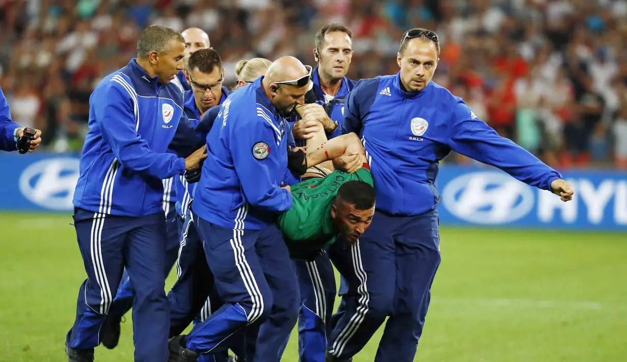 Suporter nekat Portugal berhasil diringkus petugas keamanan saat Portugal melawan Polandia pada perempat final Piala Eropa 2016 di Stade Velodrome, Marseille, (1/7/2016) dini hari WIB. (REUTERS/Kai Pfaffenbach)