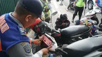 Petugas Dishub Kota Bandung menempelkan stiker sebagai sanksi kendaraan yang parkir sembarangan di Jalan Purnawarman, Jumat (14/6/2019). (Liputan6.com/Huyogo Simbolon)