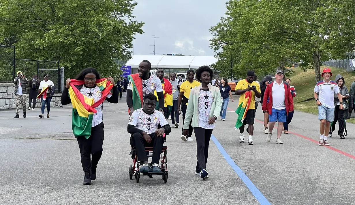 Suporter Ghana berjalan menuju Gillette Stadium, Foxborough, Boston, AS, Senin (23/6/2026). Dengan mengenakan atribut dan membawa bendera kebanggaan, mereka hadir untuk memberikan dukungan pada laga fase grup Piala Dunia 2026 melawan Inggris. (KLY Sports/Hery Kurniawan)