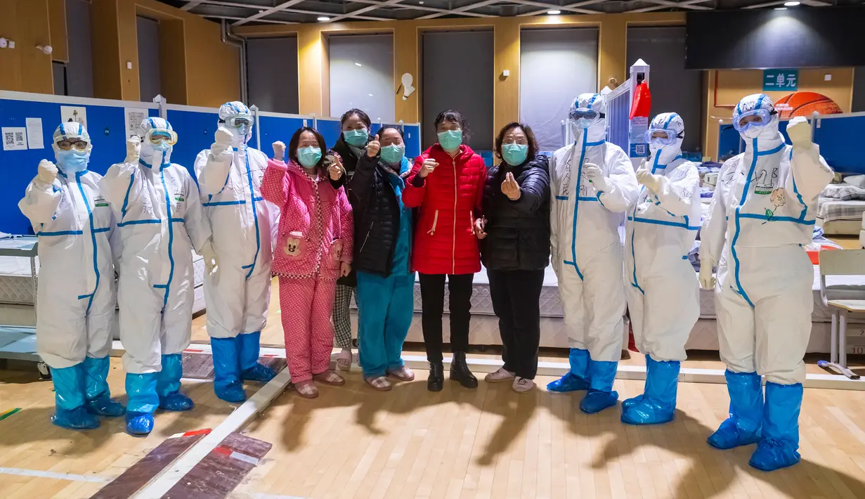 Sejumlah pasien virus corona atau COVID-19 dan para petugas medis foto bersama di sebuah rumah sakit sementara di Wuhan, China, Senin (9/3/2020). China menutup semua rumah sakit sementara yang dibuat untuk menangani virus corona di Kota Wuhan. (Xinhua/Shen Bohan)