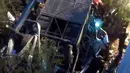Petugas berusaha mengevakuasi bangkai bus yang jatuh dari sebuah jembatan di utara Provinsi Salta, Argentina, Senin (14/12). Sedikitnya 42 polisi tewas dan lainnya terluka ketika bus yang ditumpangi menabrak jembatan dan terjun ke jurang. (AFP Photo)