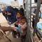 Seorang anak pengungsi Palestina mengambil sebungkus roti sementara yang lain menunggu giliran mereka dari salah satu dapur amal di kamp pengungsi Bureij, Jalur Gaza Tengah pada Senin 18 Mei 2026. (Eyad Baba/AFP)