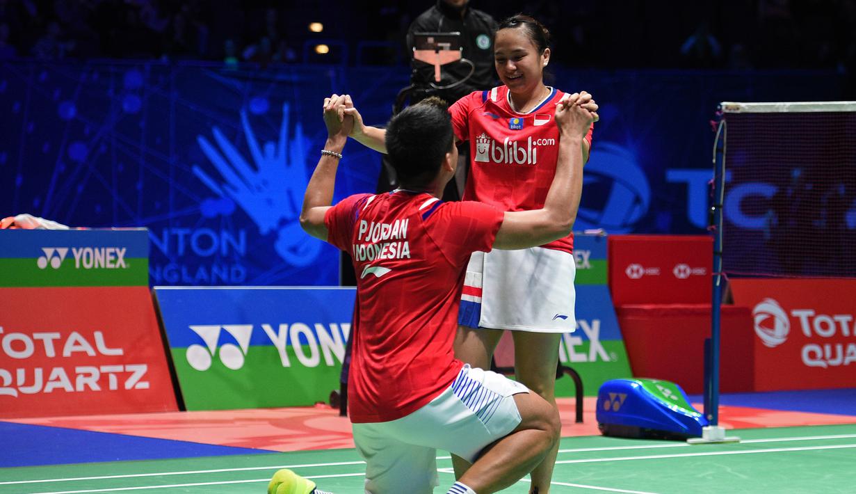 Pasangan Indonesia, Praveen Jordan/Melati Daeva Oktavianti melakukan selebrasi usai meraih juara All England dengan mengalahkan wakil Thailand Dechapol Puavaranukroh/Sapsiree Taerattanachai di Birmingham Arena, Minggu (15/3/2020). (AFP/Oli Scarff)