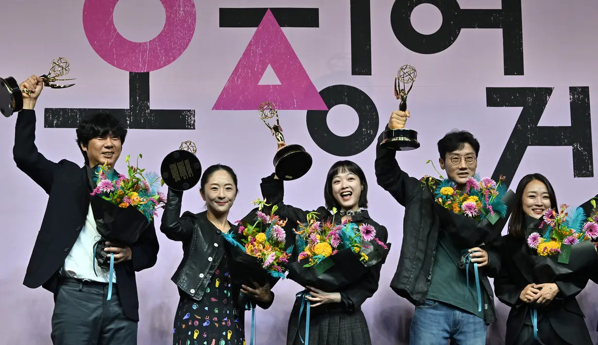 Aktris Korea Selatan Lee Yoo-mi dan Sutradara Hwang Dong-hyuk berpose dengan anggota staf serial Netflix "Squid Game" selama konferensi pers perayaan Emmy di Seoul, Korea Selatan (16/9/2022). Squid Game mencatat sejarah baru dengan menambah dua piala Emmy Awards 2022 sehingga totalnya menjadi enam. (AFP/Jung Yeon-je)