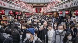 Orang-orang mengunjungi kuil Sensoji menjelang liburan Tahun Baru di Tokyo pada 30 Desember 2022. Kuil Sensoji dikenal sebagai tempat wisata paling terkenal di Tokyo. (AFP/Yuichi Yamazaki)