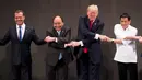 Ekspresi Presiden AS, Donald Trump saat bersalaman khas ASEAN dengan para pemimpin lainnya di penghujung upacara pembukaan KTT ASEAN di Manila, Filipina, Senin (13/11). Trump kesulitan menempatkan tangannya di posisi yang pas. (AP/Andrew Harnik)