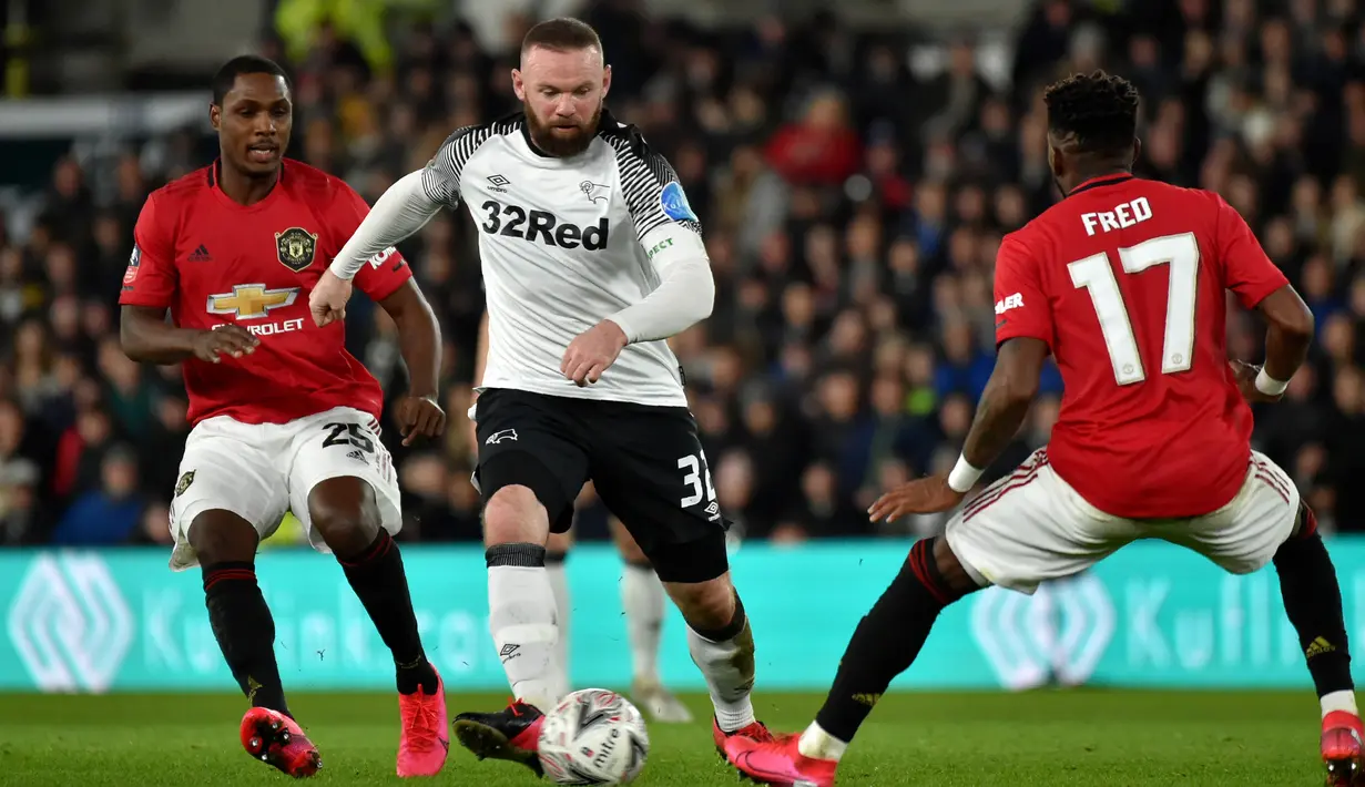 Pemain Derby County Wayne Rooney (tengah) mencoba melewati pemain Manchester United Odion Ighalo (kiri) dan Fred pada pertandingan putaran kelima Piala FA di Pride Park, Derby, Inggris, Kamis (5/3/2020). Manchester United menang dengan skor 3-0. (AP Photo/Rui Vieira)