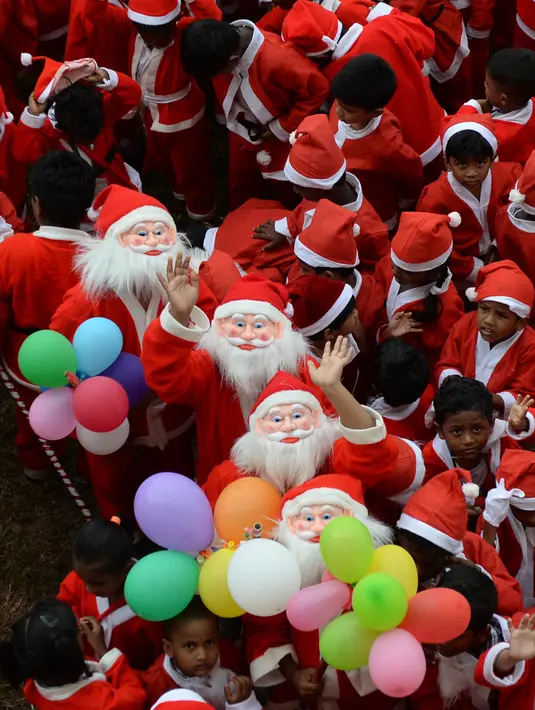 Anak-anak sekolah India mengenakan kostum Santa Claus berpose saat mereka mengambil bagian dalam acara Natal di sebuah sekolah di Chennai, (5/12). Natal adalah hari raya umat Kristen yang diperingati setiap tanggal 25 Desember. (AFP Photo/Arun Sankar)