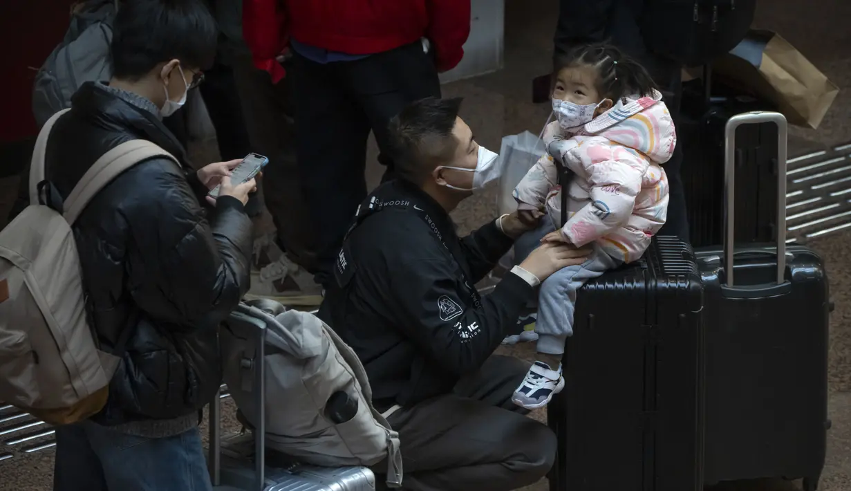 Seorang anak duduk di atas koper di Stasiun Kereta Api Beijing Barat di Beijing, Rabu, 18 Januari 2023. China pada Desember mencabut kebijakan "nol-COVID" yang ketat, melepaskan gelombang keinginan perjalanan yang terpendam, terutama di sekitar waktu terpenting China untuk pertemuan keluarga, yang disebut di China sebagai Festival Musim Semi, yang mungkin satu-satunya waktu di satu tahun ketika pekerja perkotaan kembali ke kampung halaman mereka. (AP Photo/Mark Schiefelbein)
