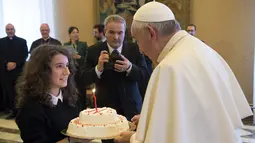 Paus Fransiskus saat menerima sebuah kue ulang tahun dari remaja anggota Italian Catholic Action saat ulang tahun ke-79 tahun di Vatikan, Kamis (17/12/2015). (REUTERS/Osservatore Romano)