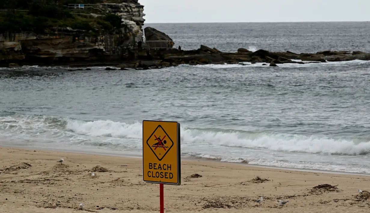 Ratusan bola hitam misterius seperti ter telah terdampar di pantai Sydney yang populer, mendorong penjaga pantai untuk menutup pantai tersebut bagi para perenang. (Saeed KHAN/AFP)
