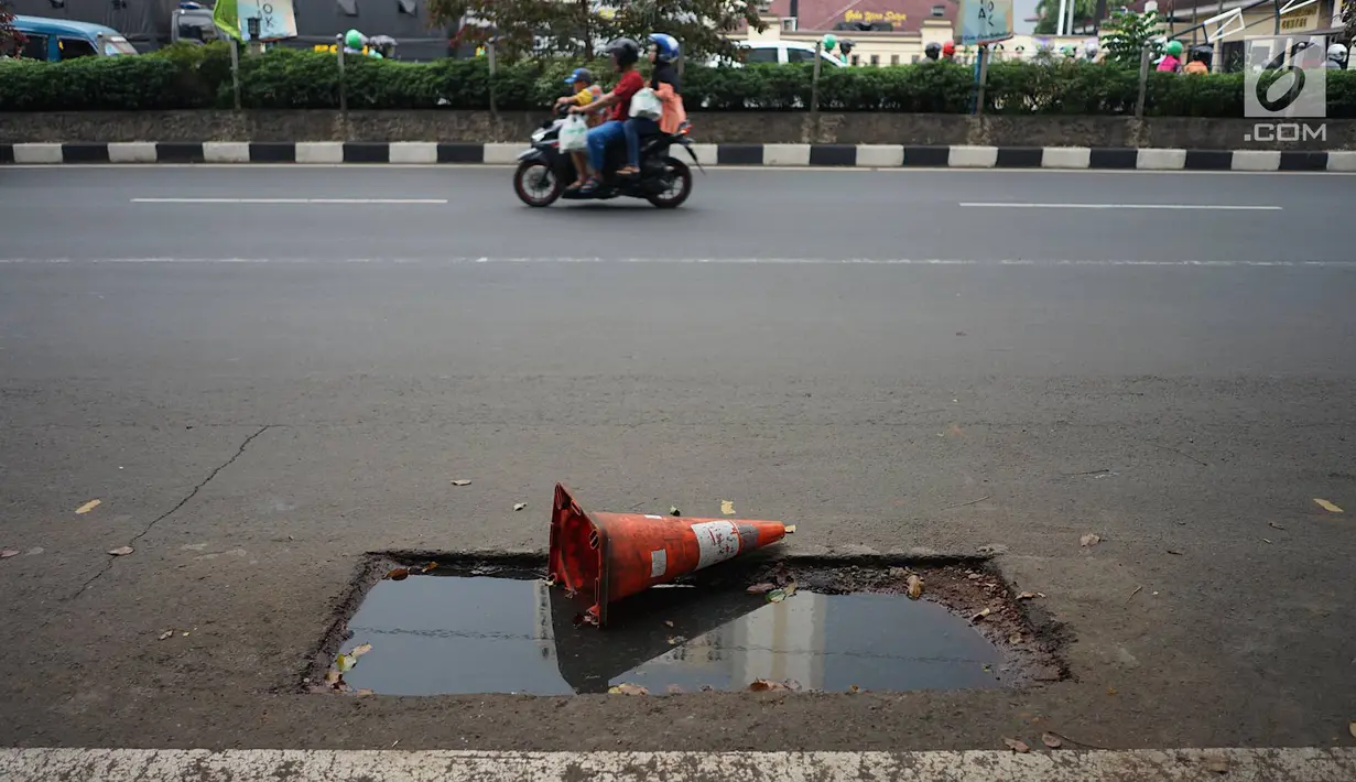 Kendaraan melintas di samping bekas galian proyek yang tidak tuntas pengerjaannya di Jalan Margonda Raya, Depok, Jawa Barat, Kamis (9/5/2019). Kondisi jalan yang diabaikan selama beberapa bulan terakhir tersebut memersempit dan mengganggu aktivitas warga. (Liputan6.com/Immanuel Antonius)