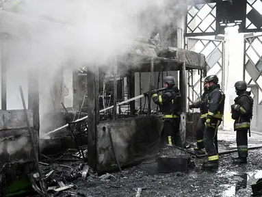 Tim penyelamat Ukraina bekerja untuk memadamkan api di sebuah terminal bus listrik setelah serangan pesawat tak berawak di Kharkiv pada 30 Mei 2025, di tengah-tengah invasi Rusia ke Ukraina. (SERGEY BOBOK/AFP)