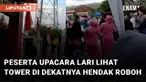 Peserta upacara dan para penonton berhamburan lari melihat tower di dekatnya hendak roboh mengundang perhatian