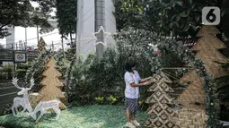 Umat nasrani mendekorasi Natal di Gereja Katolik Santo Stefanus, Jakarta, Selasa (20/12/2022). Pada perayaan Natal 2022 dengan mengusung tema “Green Christmas” mereka membuat pohon Natal dari gedek, tampah, besek sedangkan ornamen goa Natal menggunakan barang bekas pakai karton telur, selongsong tissue gulung, serta buku misa paskah 2019. (Liputan6.com/Faizal Fanani)