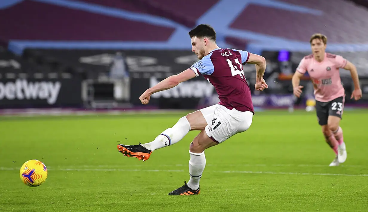 Pemain West Ham United Declan Rice menendang penalti ke gawang Sheffield United pada pertandingan Liga Inggris di London Stadium, London, Inggris, Senin (15/2/2021). West Ham United menang 3-0. (Justin Setterfield/Pool via AP)