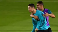 Pemain Real Madrid, Cristiano Ronaldo bercanda dengan rekannya Casemiro saat latihan di Stadion NY University Abu Dhabi, UAE, Senin (11/12/2017). Los Blancos bersiap jelang semifinal FIFA Club World Cup. (AFP/Giuseppe Cacace)