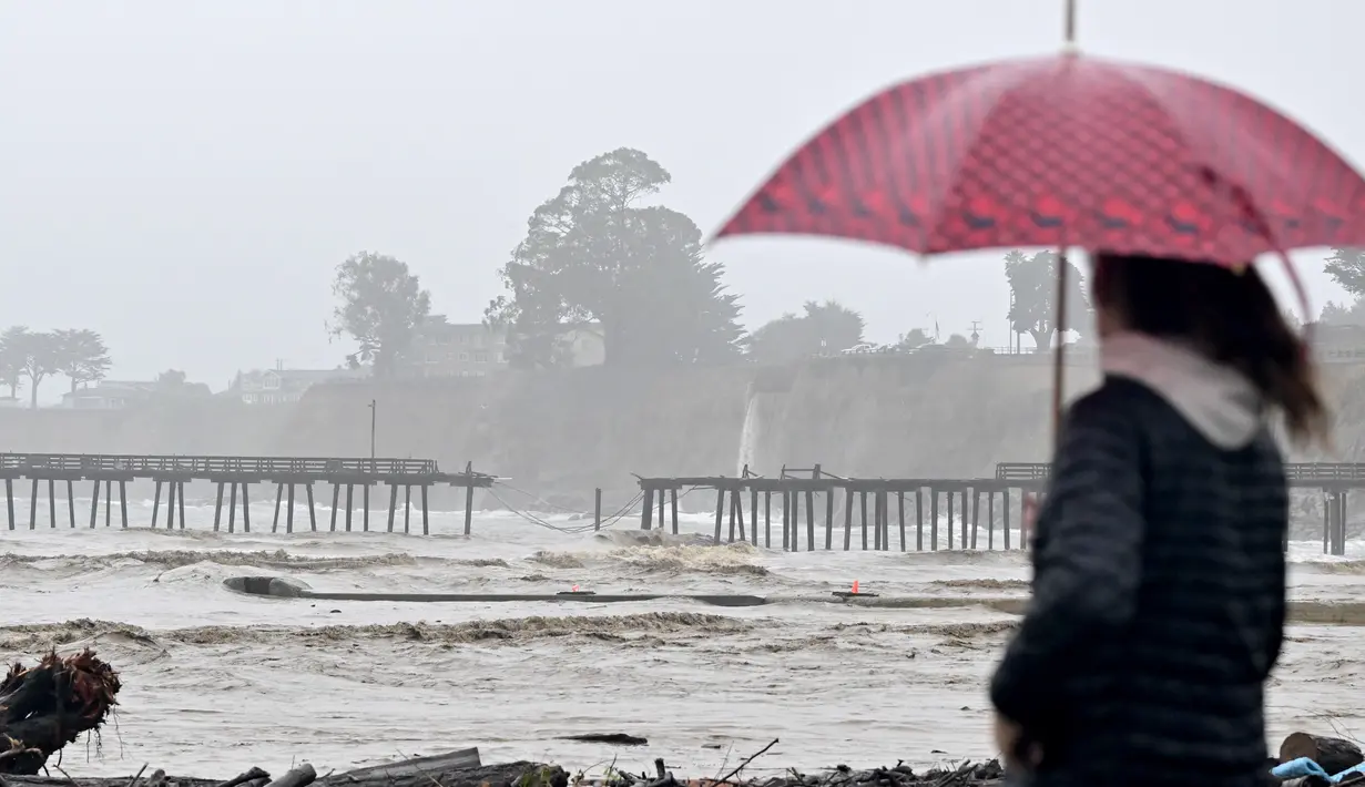 Warga melihat Dermaga Capitola terbelah dua dari Aptos, California pada 9 Januari 2023. Badai besar yang disebut "badai bom" oleh ahli meteorologi telah tiba dan diperkirakan akan menyebabkan banjir yang meluas di seluruh negara bagian. (AFP/Josh Edelson)