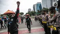 Petugas kepolisian berjaga saat unjuk rasa massa yang tergabung dalam Serikat Pekerja Indonesia (KSPI) di kawasan Patung Kuda, Jakarta, Rabu (16/12/2020).  Unjuk rasa berlangsung mulai pukul 10:00 - 12:00 WIB. (Liputan6.com/Faizal Fanani)