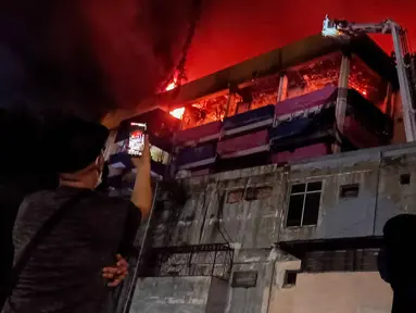 Warga merekam suasana kebakaran yang melanda pertokoan Glodok Plaza, Jakarta, Rabu (15/1/2025). (Liputan6.com/Herman Zakharia)