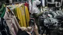 Pedagang menjualkan pakaian melalui melalui aplikasi online di Pasar Tanah Abang, Jakarta, Rabu (1/7/2020). Pedagang di Pasar Tanah Abang mulai menjual barang secara daring untuk menambah penjualan dan mengantisipasi turunnya jumlah pembeli di masa PSBB Transisi ini. (Liputan6.com/Faizal Fanani)