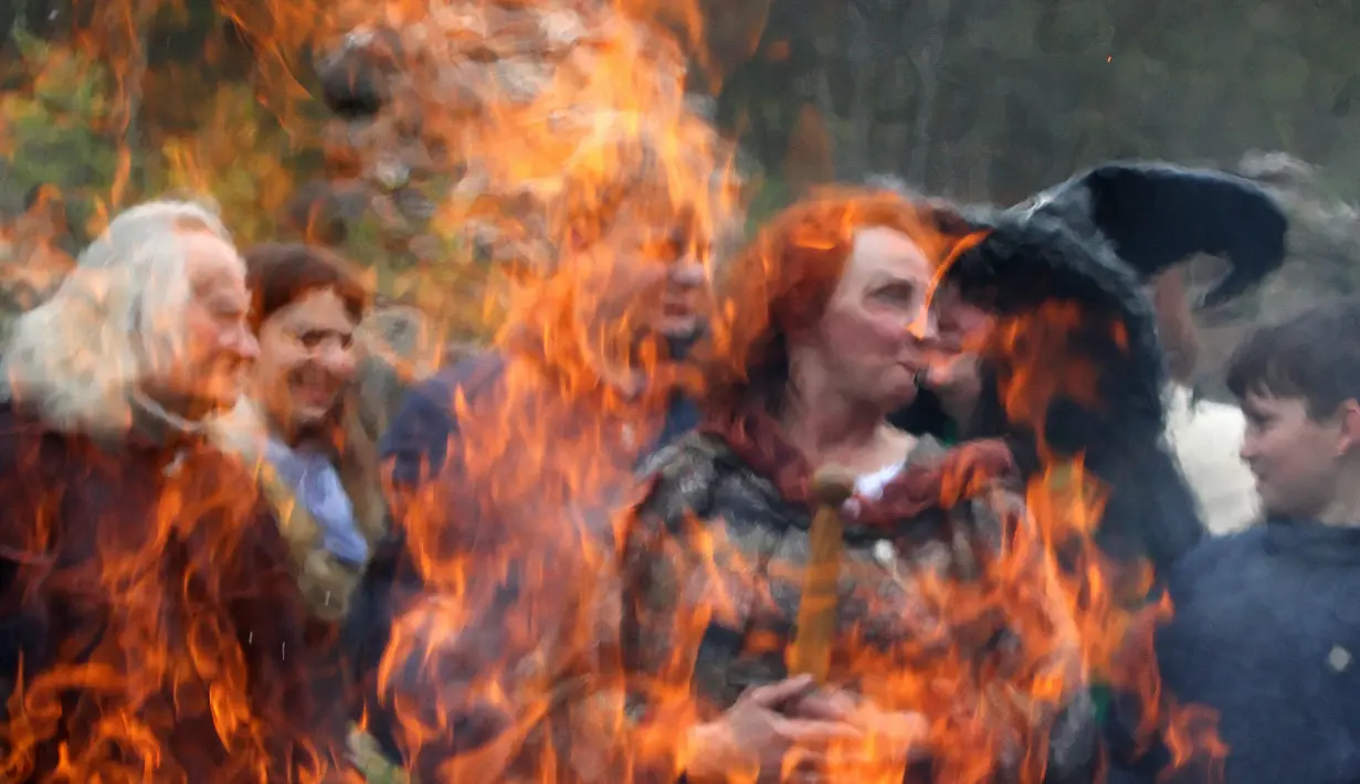 Sejumlah orang berkumpul untuk menggelar ritual sihir di acara Walpurgis Night atau Witches Night di Vilnius, Lithuania, Senin (1/5). Orang-orang yang hadir mengenakan atribut layaknya para penyihir. (AFP PHOTO / Petras Malukas)