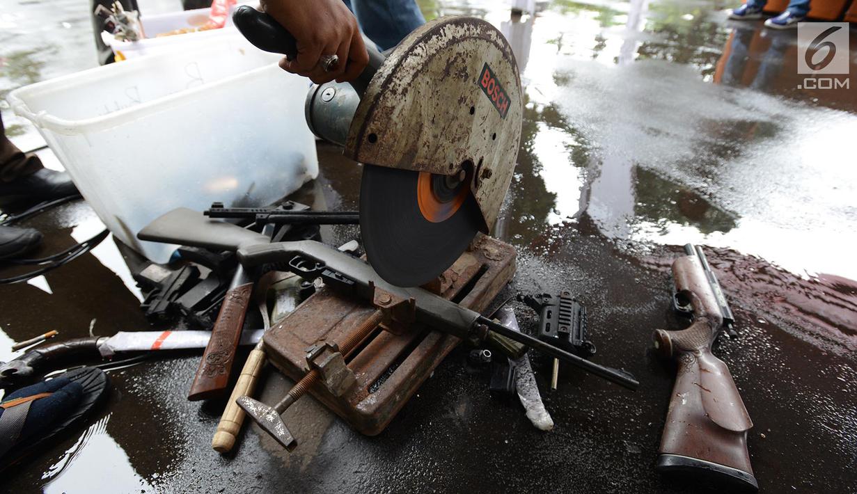 Senjata api dimusnahkan menggunakan mesin pemotong besi di Kejaksaan Negeri Jakarta Timur, Rabu (24/4). Barang bukti yang dimusnahkan berupa senjata api, senjata tajam dan beberapa jenis narkoba hasil pengungkapan kasus hukum di wilayah Jakarta Timur periode 2018-2019. (merdeka.com/Imam Buhori)